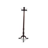 A GEORGE IV STYLE MAHOGANY HAT AND COAT STAND, raised on tripod supports with paw feet. 186cm high