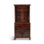 A LATE GEORGE III MAHOGANY BREAKFRONT BOOKCASE, the top section with twin glazed doors, the bottom