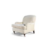 A HOWARD STYLE ARMCHAIR, upholstered in cream fabric, raised on turned front supports, with brass