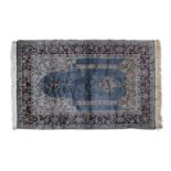 A FINE PERSIAN SILK AND WOOL PRAYER RUG, woven in blue and cream tones, the large centre field woven