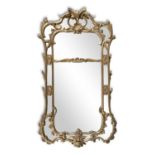 A CARVED GILTWOOD COMPARTMENTED MIRROR, 19TH CENTURY, with shaped and scrolled cresting, the