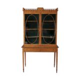 AN EDWARDIAN INLAID SATINWOOD TWIN GLAZED DOOR DISPLAY CABINET, on table base, fitted two drawers.