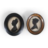 TWO VICTORIAN OVAL SILHOUETTES OF FEMALE BUSTS, profiles to the right, one wearing a bonnet and wide