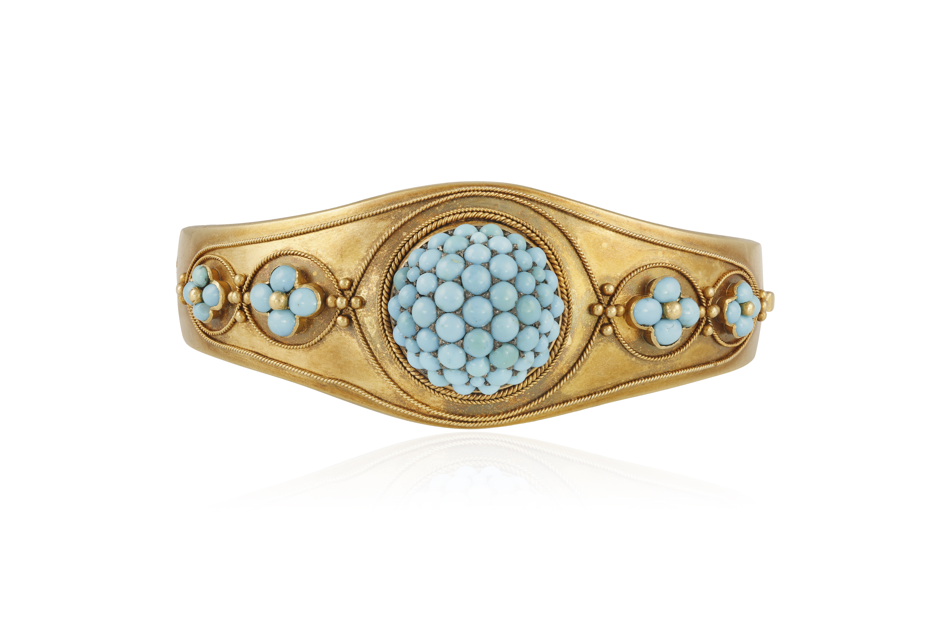 A VICTORIAN TURQUOISE BANGLE, CIRCA 1860 The hinged bangle set with a domed cluster of cabochon