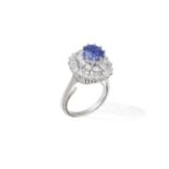 A SAPPHIRE AND DIAMOND CLUSTER RING The cushion-shaped sapphire weighing approximately 2.70cts