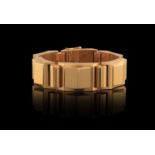 A GOLD RETRO BRACELET, CIRCA 1940 Of tank design, the articulated gold band composed of alternate