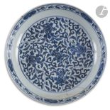 CHINE - XVIIIe siècle Plat rond en porcelaine bleu blanc à décor central de fleurs de lotus dans