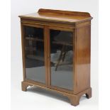 A mahogany dwarf cabinet, with two adjustable shelves enclosed by pair of glazed doors, & on bracket