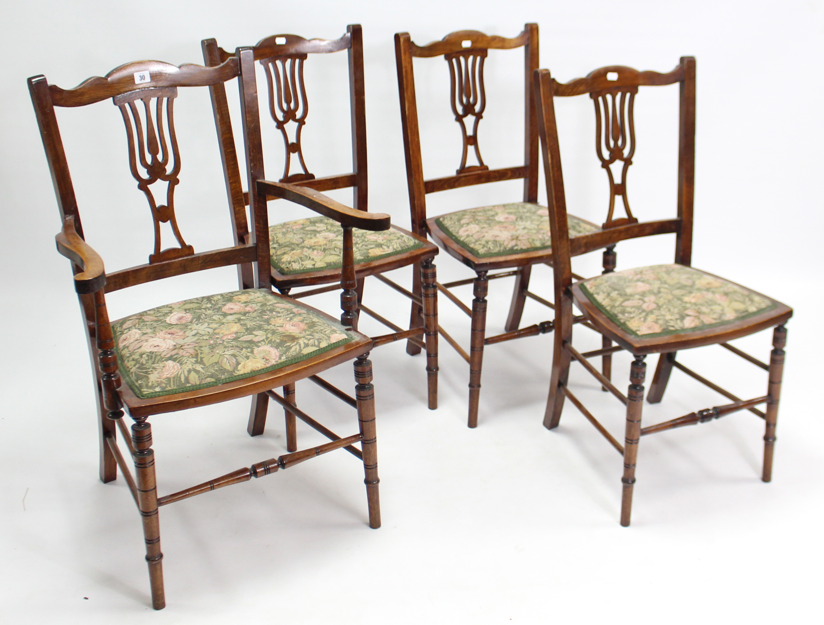 A set of four late Victorian beech splat-back dining chairs (including a pair of carvers), each with