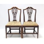 A pair of Hepplewhite-style mahogany dining chairs, each with pierced & shaped splat back, padded