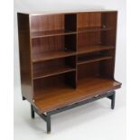 A G-Plan mahogany-finish side cabinet, fitted with an arrangement of six open shelves, & on ebonised
