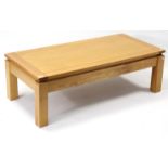 A light oak rectangular low coffee table on four short square legs, 49¼” 23½”.