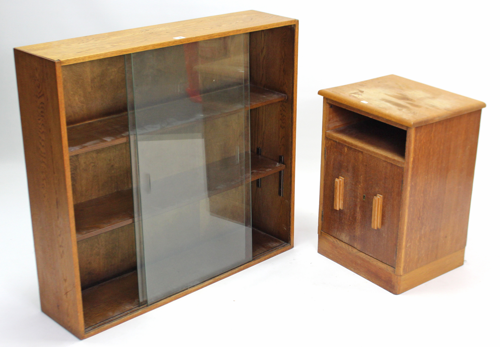 A small oak standing bookcase with two adjustable shelves enclosed by