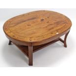 A marquetry-inlaid teak oval coffee table on four short cabriole legs with open undertier, 47½” x