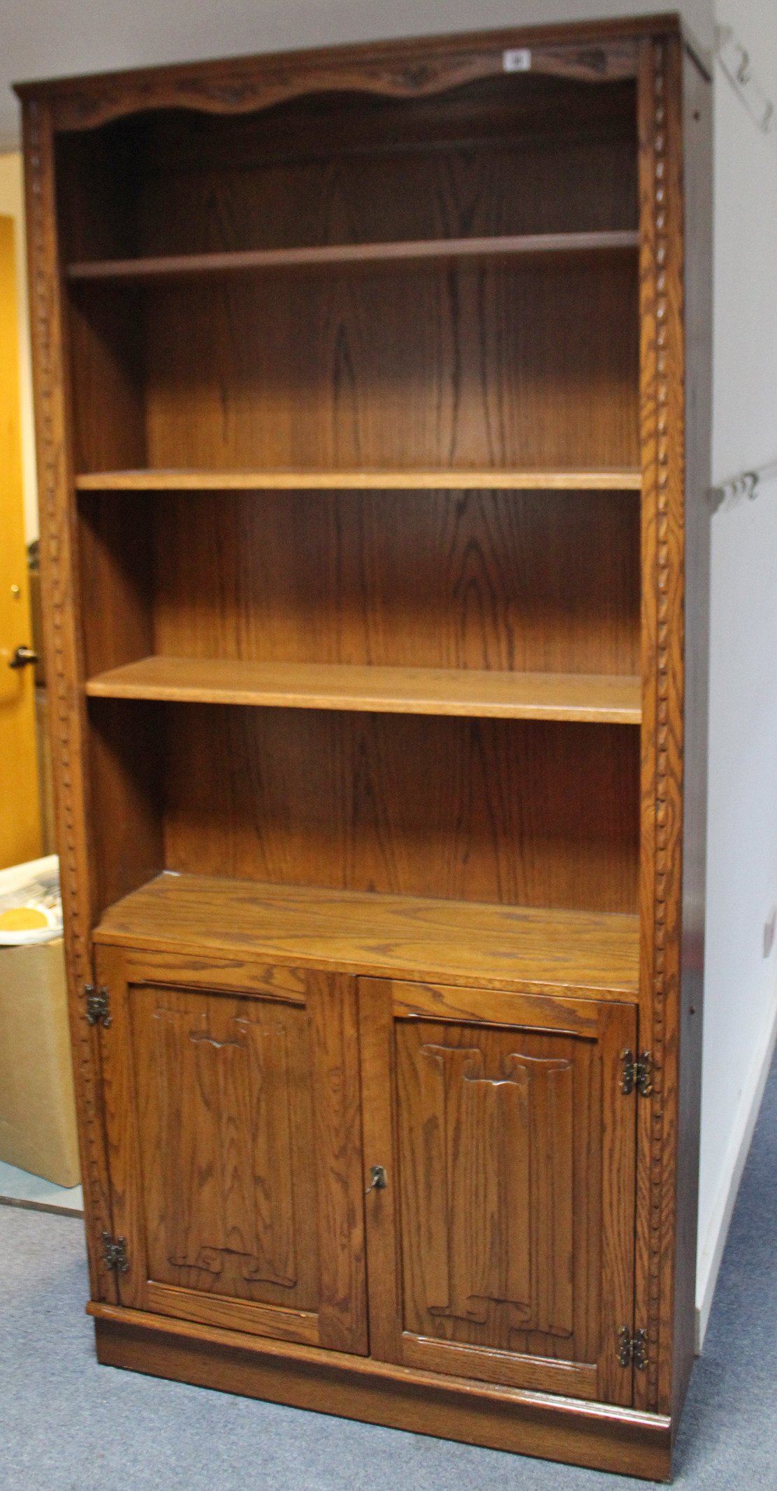 A Jaycee tall oak side cabinet with three adjustable shelves above cupboard enclosed by pair of