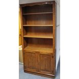 A Jaycee tall oak side cabinet with three adjustable shelves above cupboard enclosed by pair of