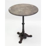 A Victorian-style black painted cast-iron pub table on triform base, with black slate top, 23” diam.