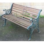 A Victorian-style green painted cast-iron & wooden slatted garden bench, 50” long.