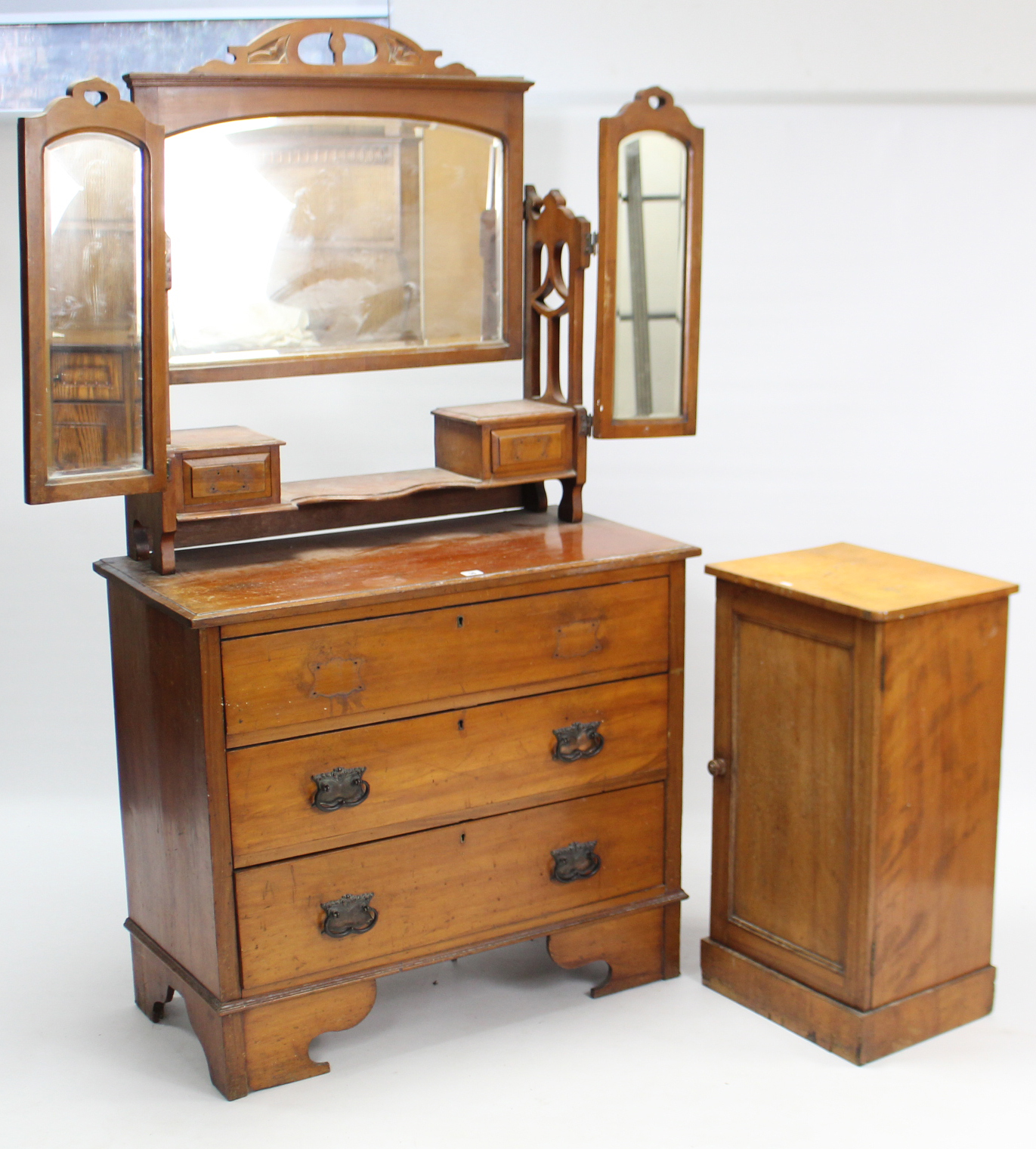 A late Victorian walnut dressing chest with triple panel mirror to the stage back, fitted three long