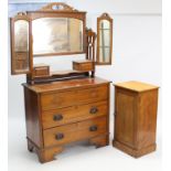 A late Victorian walnut dressing chest with triple panel mirror to the stage back, fitted three long