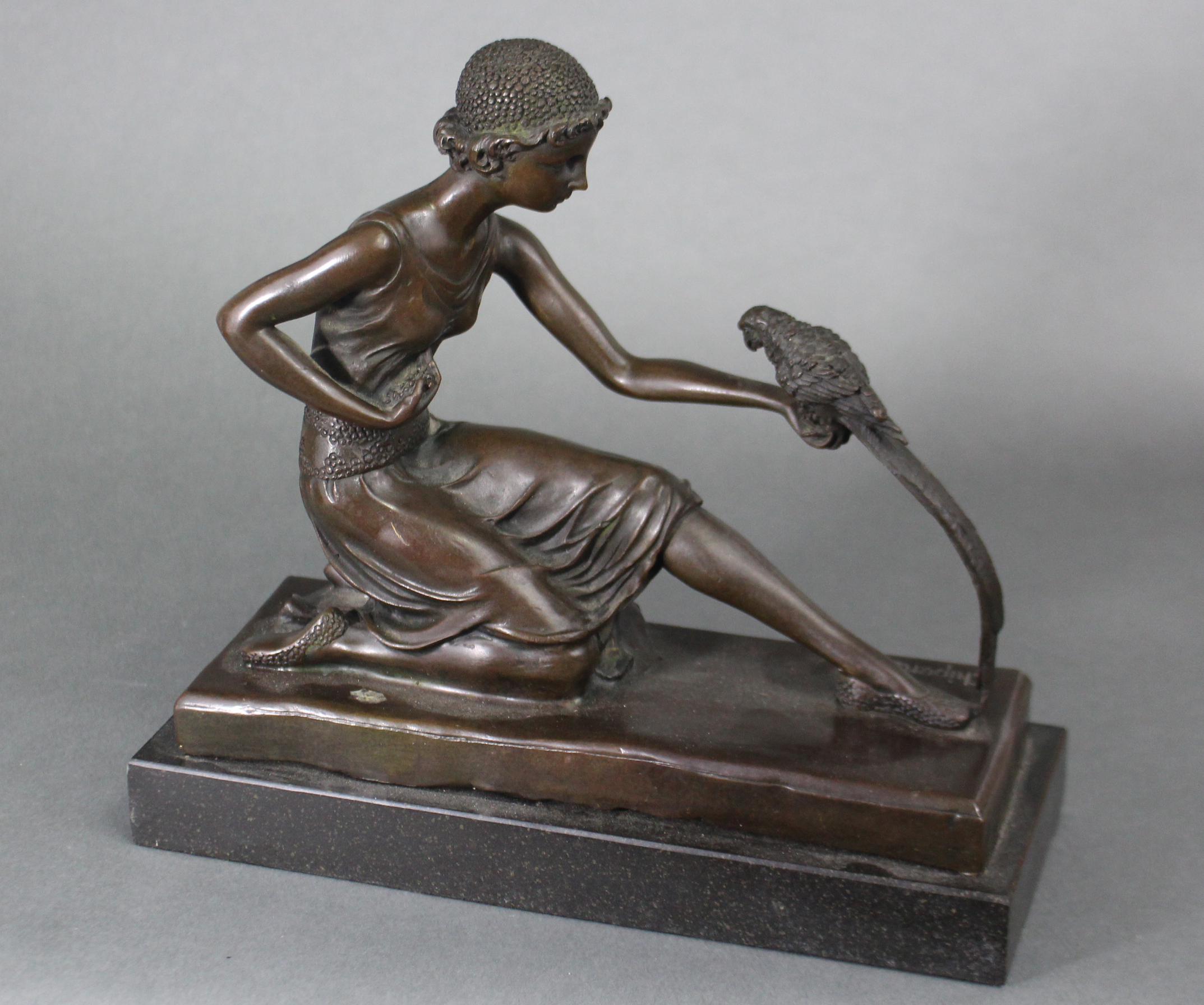 After D. H. Chiparus; a cast bronze figure of a girl in 1930s dress, on one knee feeding a parrot,