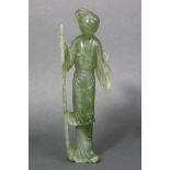 A Chinese carved pale green jade standing figure of a lady dressed in long flowing robes & holding a