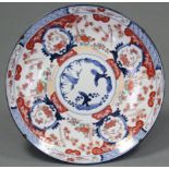 A 19th century Japanese Imari charger decorated with birds amongst trees, floral reserves, &