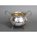 A late Victorian silver two-handled sugar bowl of round spiral fluted form, with card-cut rim & on