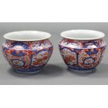 A pair of Japanese Imari jardinieres of squat round form & with flared rims, decorated with birds