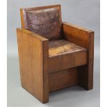 An Art Deco style oak square armchair with padded leather back & drop-in seat.