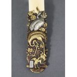 A late 19th century Japanese ivory paper knife, the embossed mixed metal handle decorated with birds