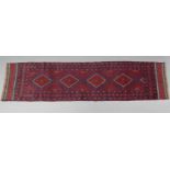 A Meshwari runner of madder ground with all-over repeating geometric design in dark blue & ivory;