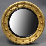 A regency-style giltwood & gesso circular convex wall mirror, with ebonised reeded inner slip &