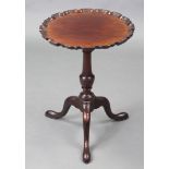 A Georgian-style mahogany wine table with pie-crust edge to the circular top, on a vase-turned
