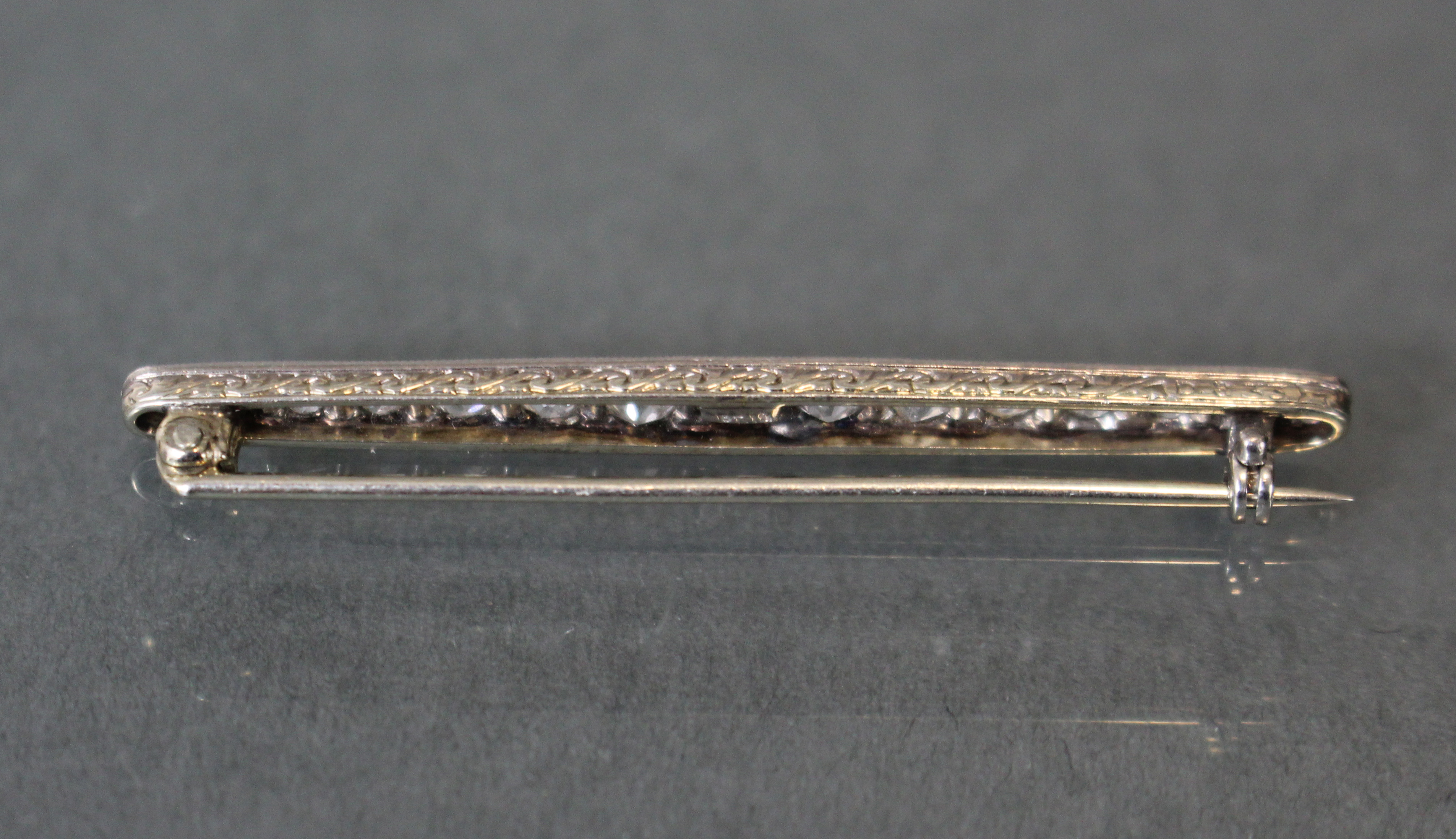 A diamond & platinum bar brooch set fifteen graduated round-cut stones, the narrow sides with - Image 3 of 3