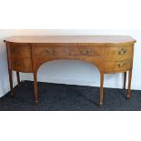 An early 19th century inlaid-mahogany bow-front sideboard, fitted two frieze drawers flanked by a