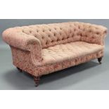 A Victorian Chesterfield settee, the buttoned-back, seat, & arms upholstered salmon pink floral