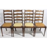 A set of four oak ladder-back dining chairs with woven string seats, & on turned tapered legs.