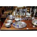 A silver plated three-piece tea service of oval form; a pair of silver plated twin-branch table