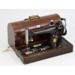A Singer hand sewing machine with oak case; together with a fibre-covered travelling trunk; &