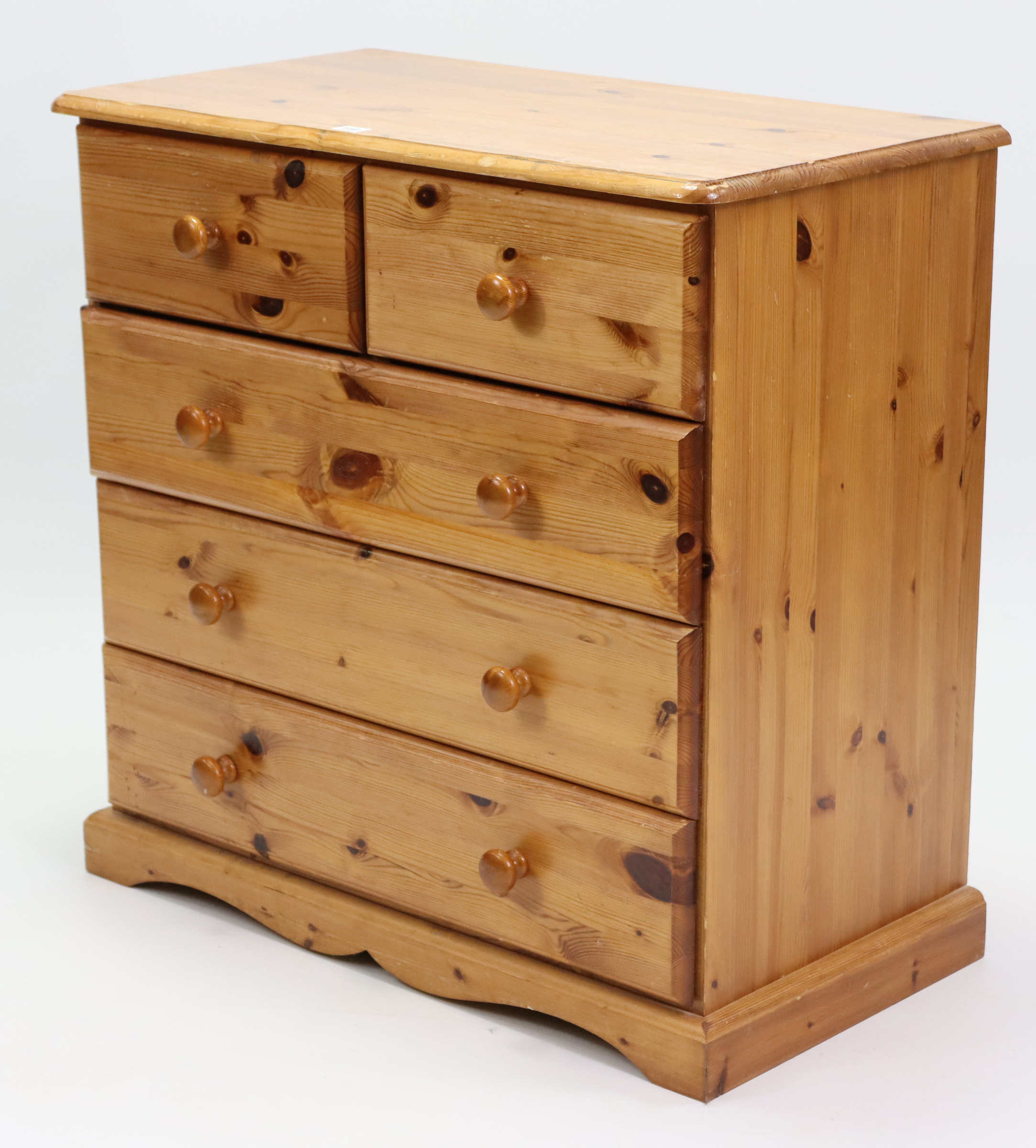 A pine small chest, fitted two short & three long drawers with turned knob handles, & on shaped