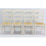 A set of four white-finish ladder-back kitchen chairs, with woven-rush seats & on square tapered