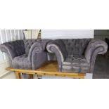 A pair of buttoned mauve velour deep easy chairs.