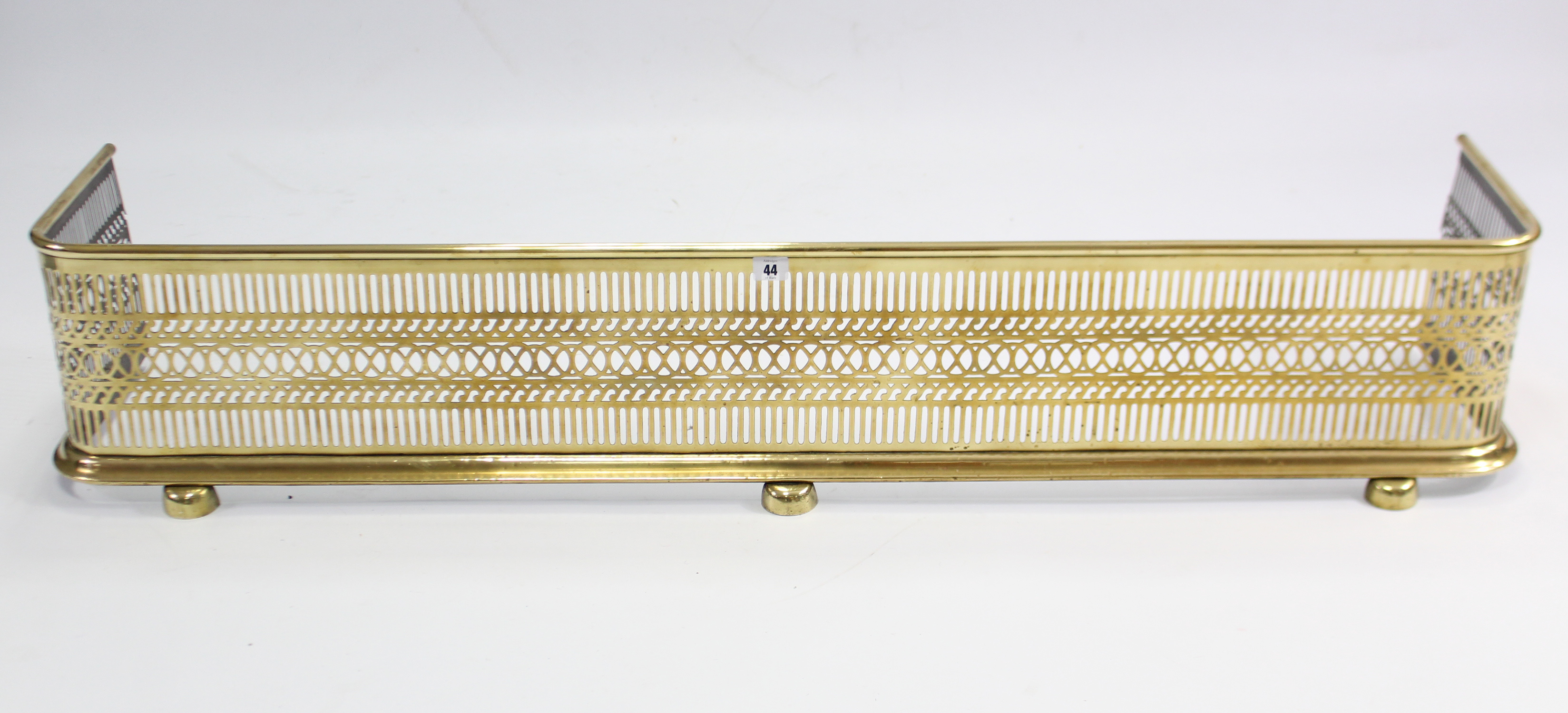 A 19th century brass fender with pierced frieze, 54” long.