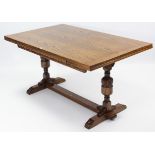 A Jaycee oak draw-leaf dining table on heavy carved bulbous-turned end supports joined by plain