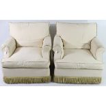 A pair of low armchairs upholstered cream fabric, with squab cushions & on Shepherd’s castors.