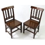 A pair of 19th century oak cottage dining chairs with rail-&-ball backs, hard seats, & on square