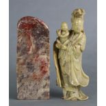 A Chinese carved soapstone figure of Guanyin, wearing flowing robes & holding an infant, 6¾” high;