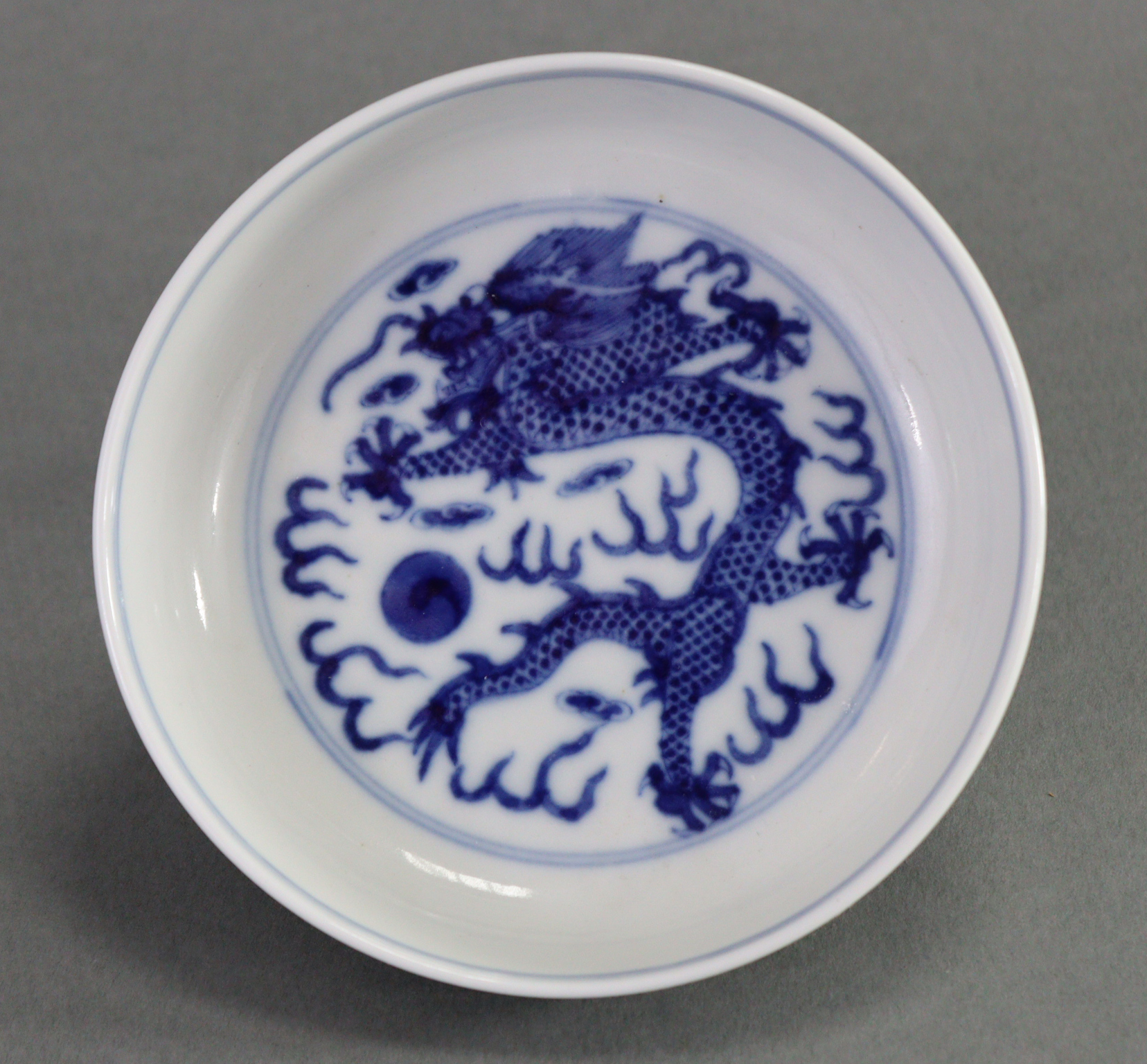 A Chinese blue & white porcelain small circular dish with raised border, the centre painted with a