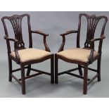 A pair of 19th century Chippendale-style mahogany elbow chairs, each with carved foliate